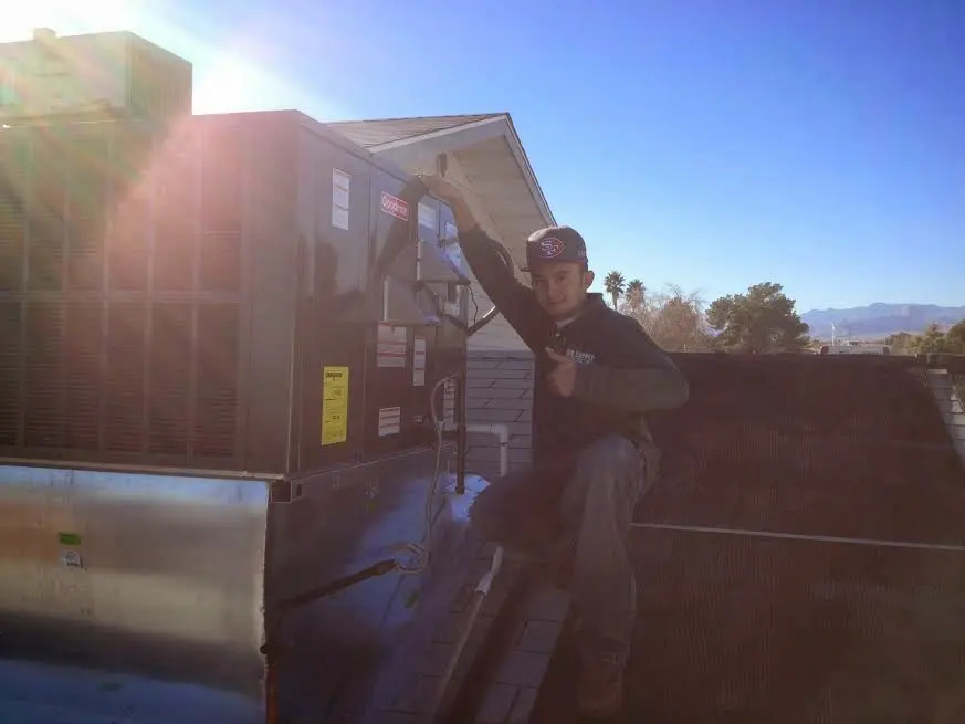 HVAC technician performing Heat Pump Repair on a rooftop unit in Glenn Heights